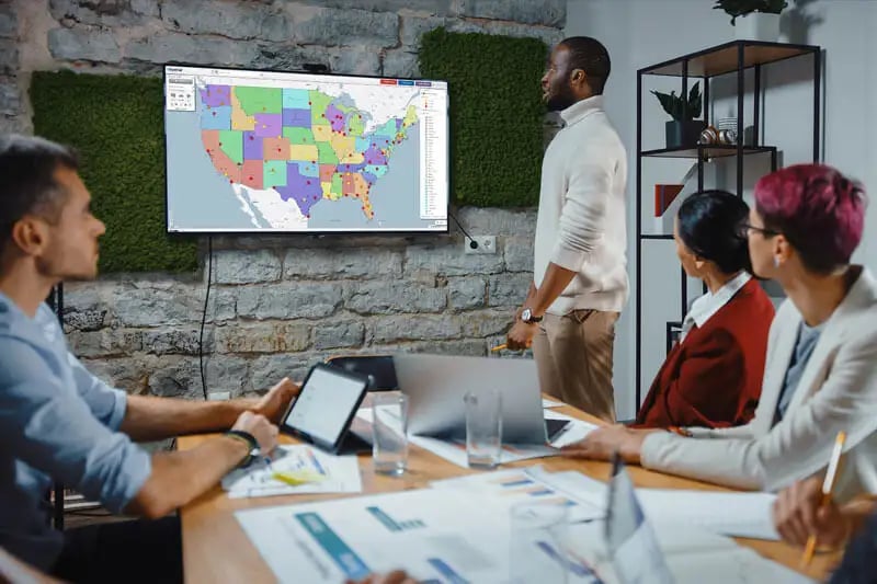 Meeting with a map on a TV screen on the wall