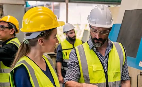 2 people wearing helmets and hi-vis vests